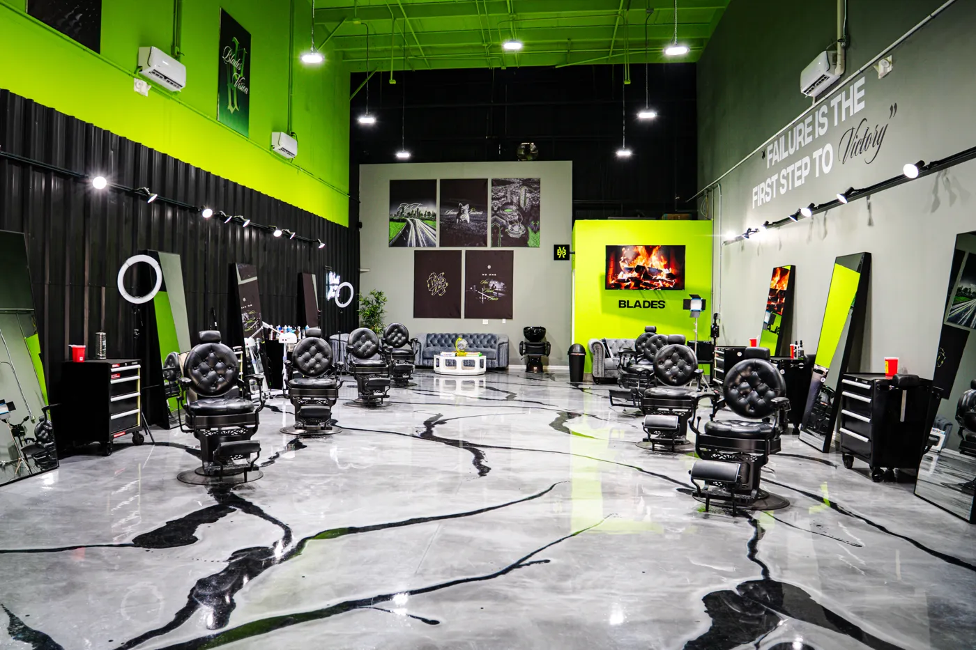Inside Blades Vision Barbershop in Houston, TX — barber chairs and green accent walls. Book your chair